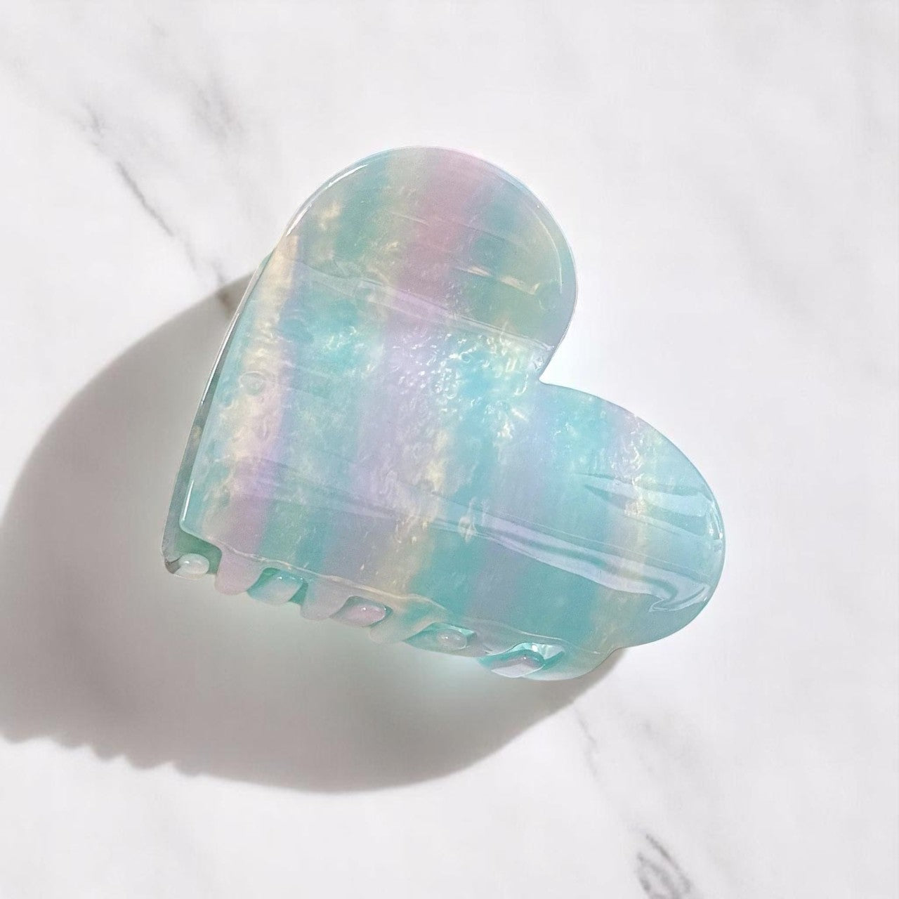 Aqua heart-shaped hair clip on marble surface