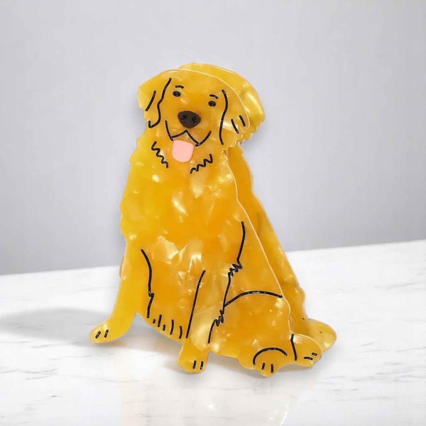 Acrylic golden retriever hairpin on a marble surface.
