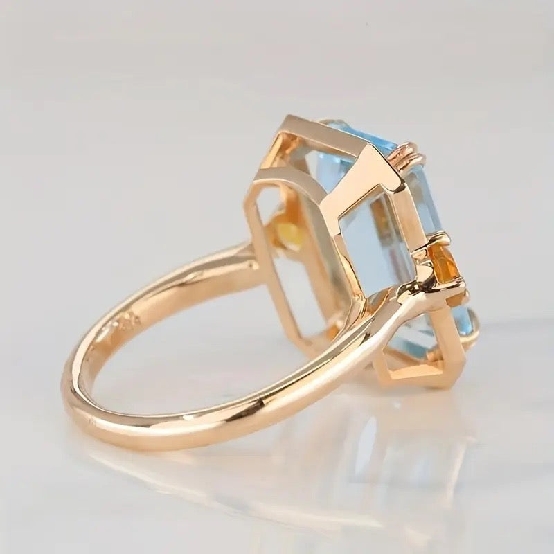 Fashion cocktail ring featuring faux blue topaz and citrine-inspired stones in gold-tone.