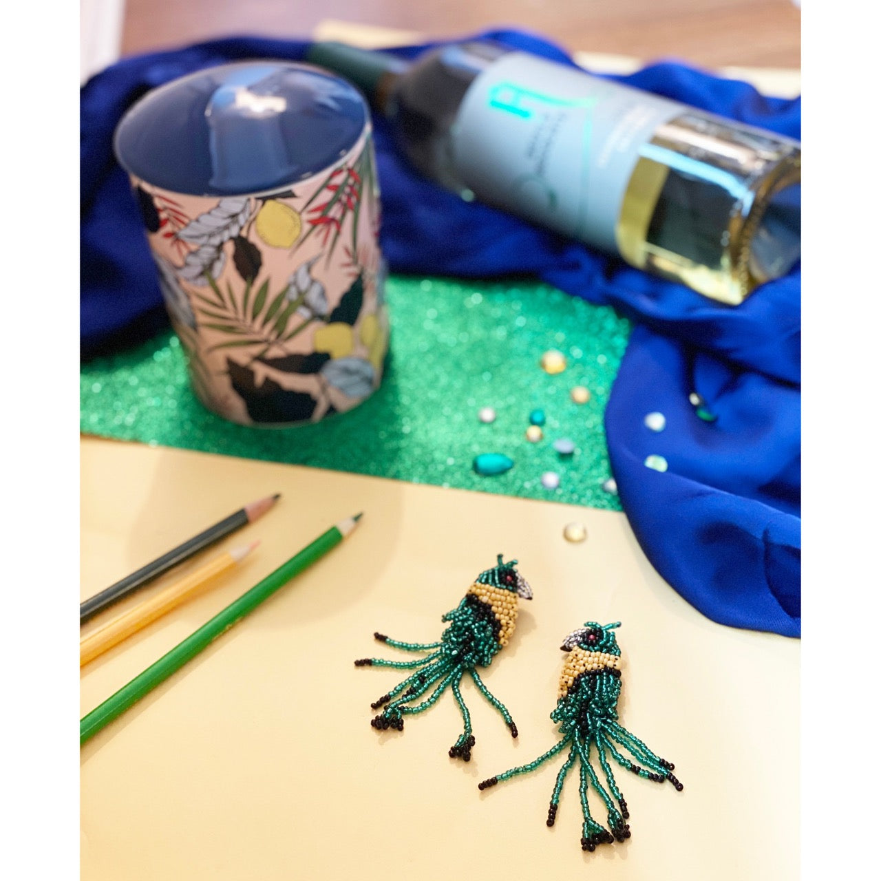 Handmade hypoallergenic bird earrings with green and yellow beads and unique detail.