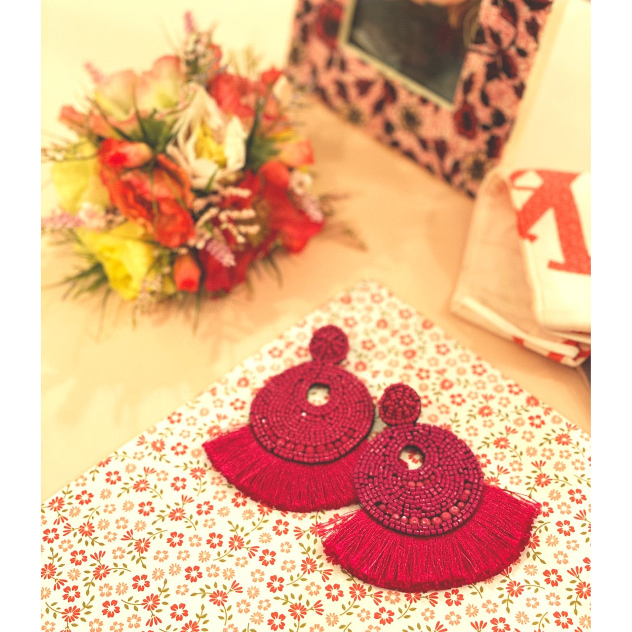 Statement earrings in fuchsia with rainbow fringe and a lollipop motif.