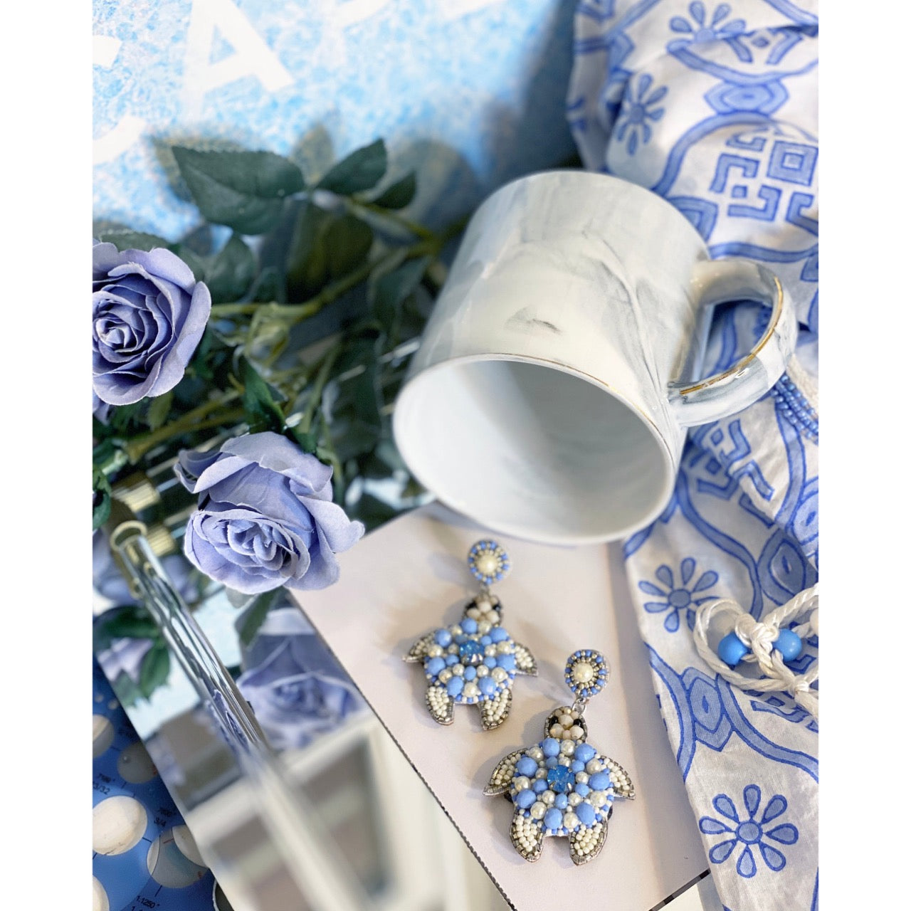 Ocean-inspired turtle earrings with pearl and aquamarine bead detailing, showcasing a fun "Good Vibes" patch.