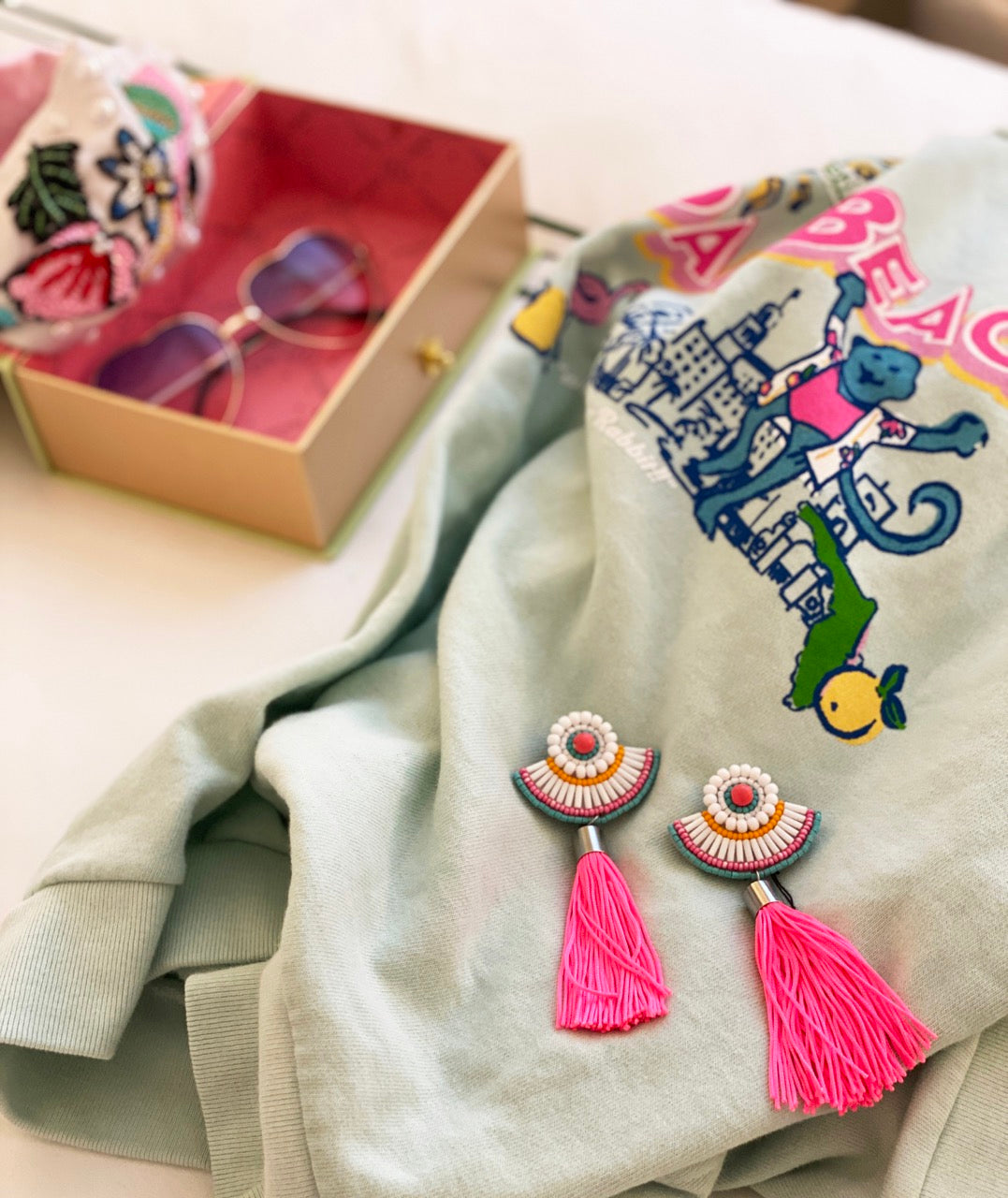 Bold pink tassel earrings with contrasting shades and a WTF patch design, perfect for a trendy and fun look.