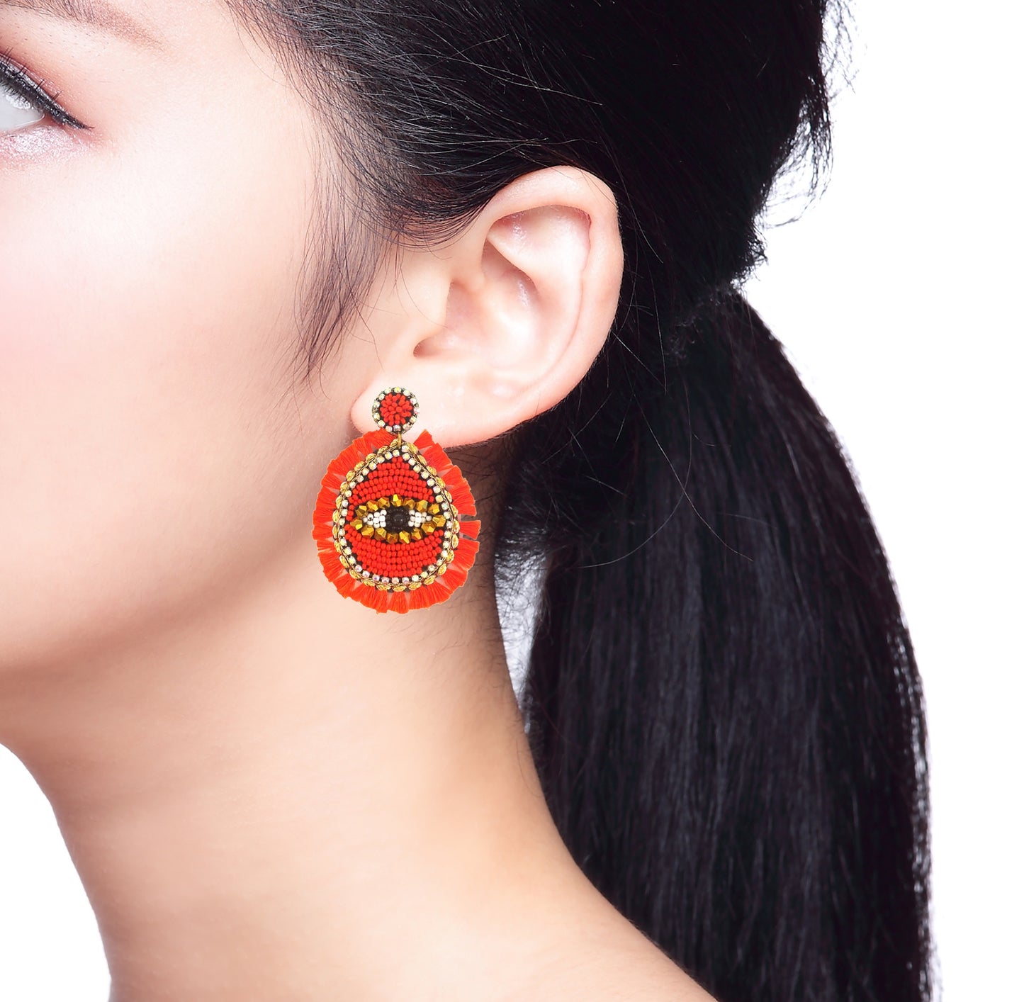 Pair of evil eye tassel earrings against a white background, emphasizing their unique and colorful design.