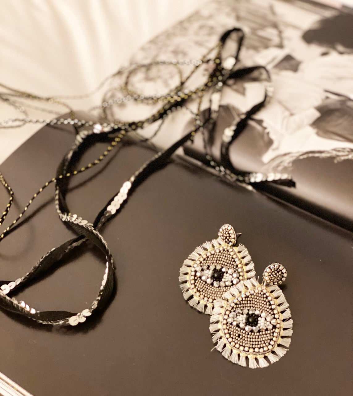 Handcrafted silver tassel earrings with evil eye motif, perfect for adding a bold statement to any outfit.