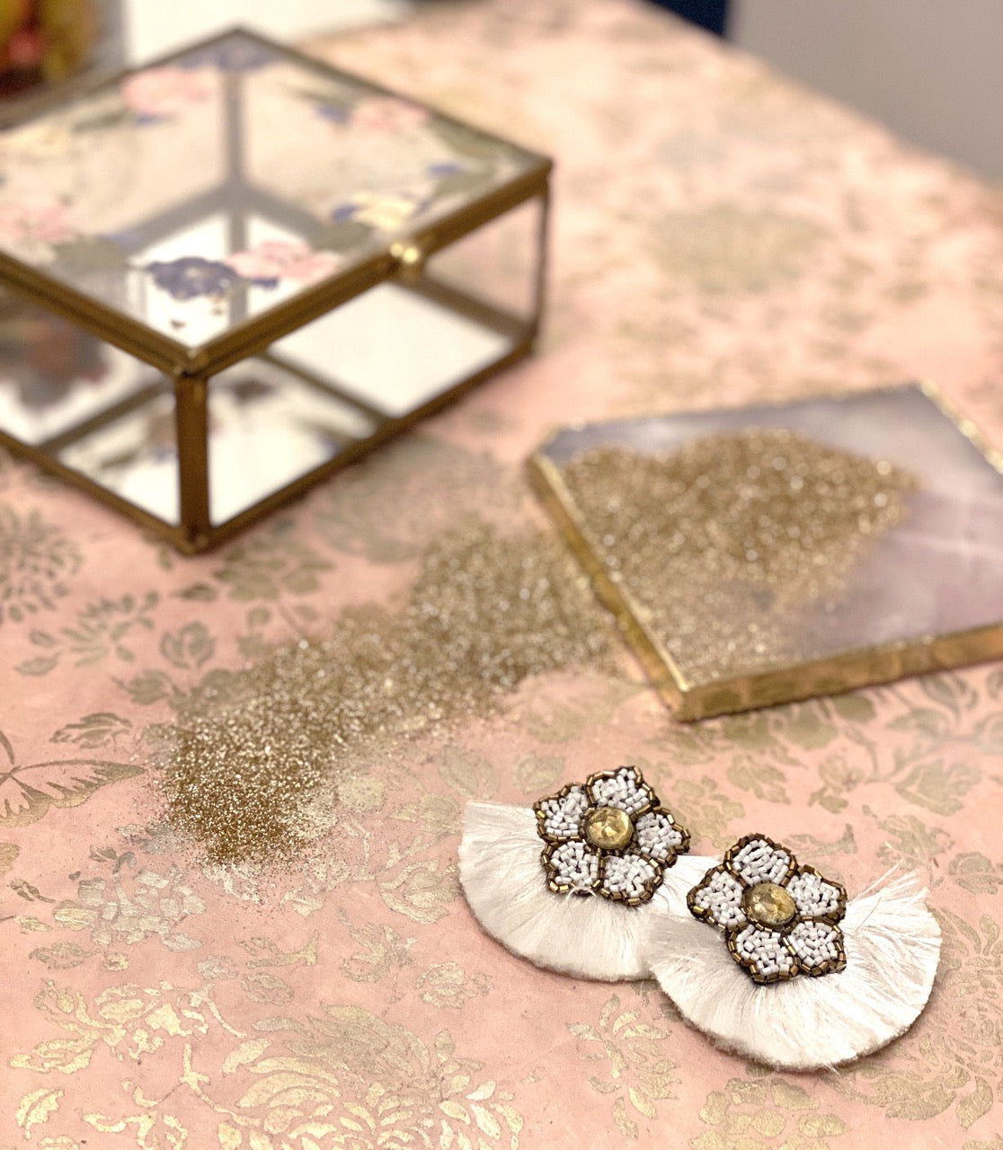 White fringe statement earrings with floral bead detailing and human rights messaging, ideal for bold style advocates.