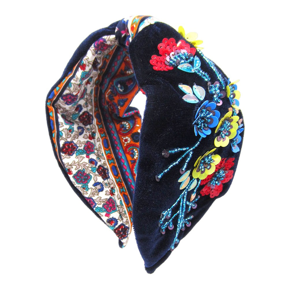 White and pink floral headband with beaded embellishments on a white background, providing a bohemian and feminine touch to any outfit.