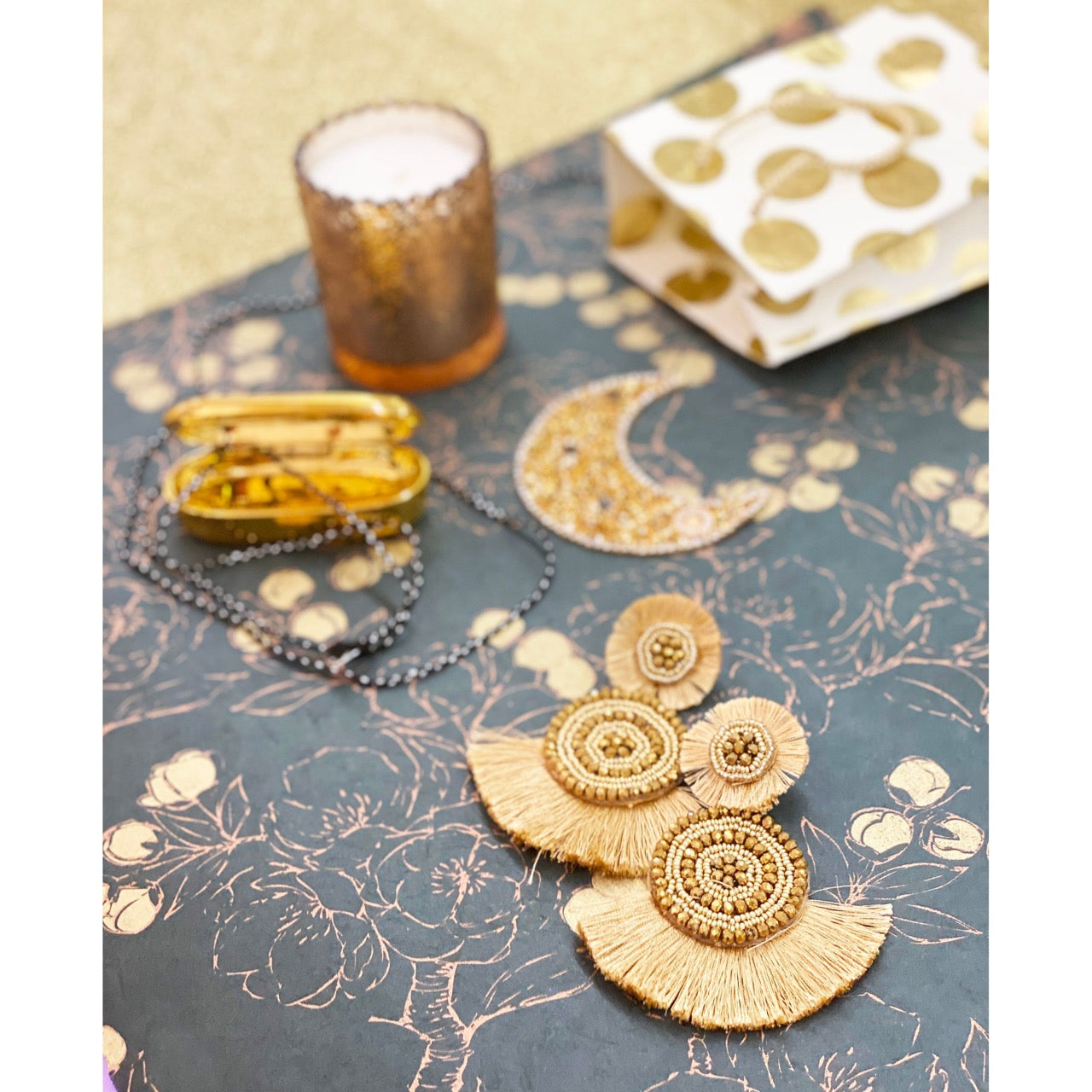 Gold statement earrings with layered fringe, beaded circles, and cheeky patch embellishments
