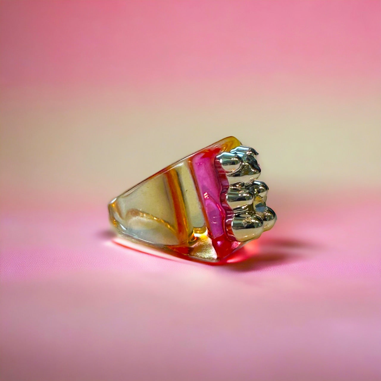 Adorable pink gummy bear ring, adorned with a sparkling gold band, adds a touch of whimsy to any outfit.