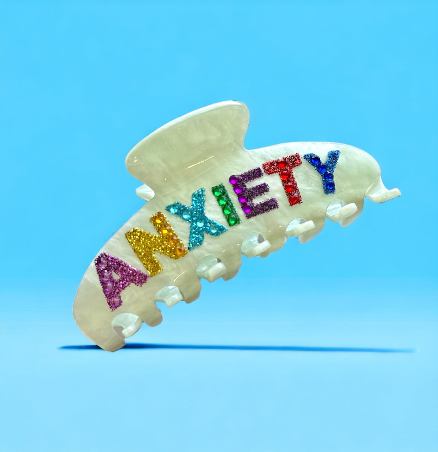 Playful green hair clip with rainbow rhinestone "ANXIETY" text, lightweight and easy to wear.