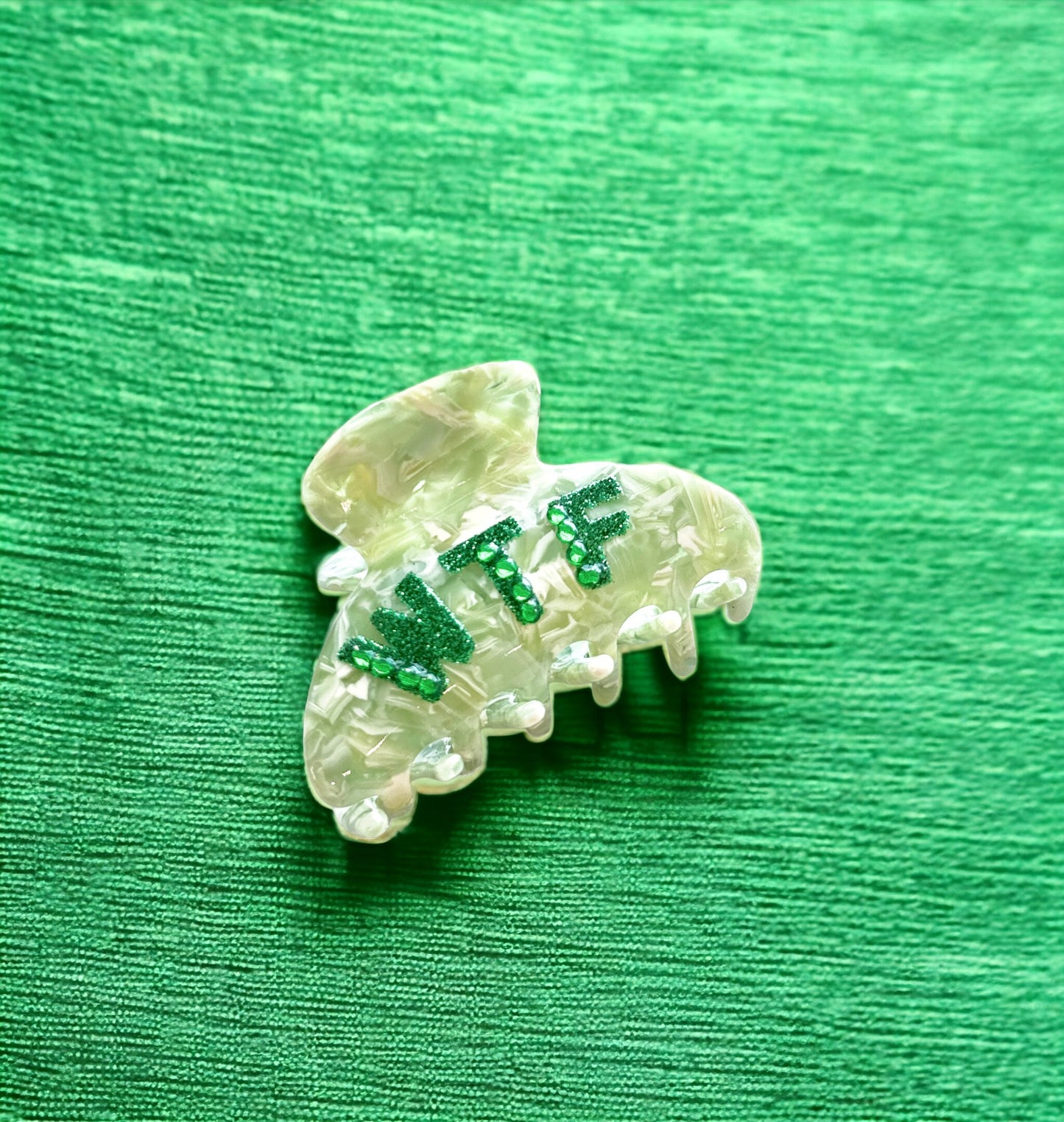WTF hair clip with sparkling green rhinestones, made from durable blue acetate, perfect for adding attitude to your look.