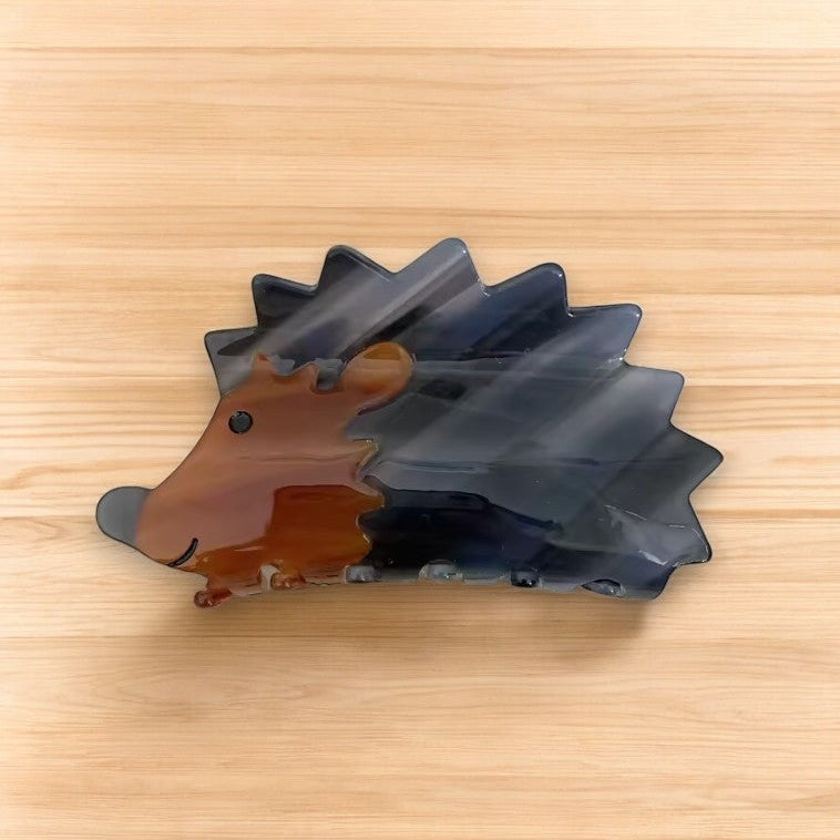 Adorable hedgehog hair clip on a wooden surface.