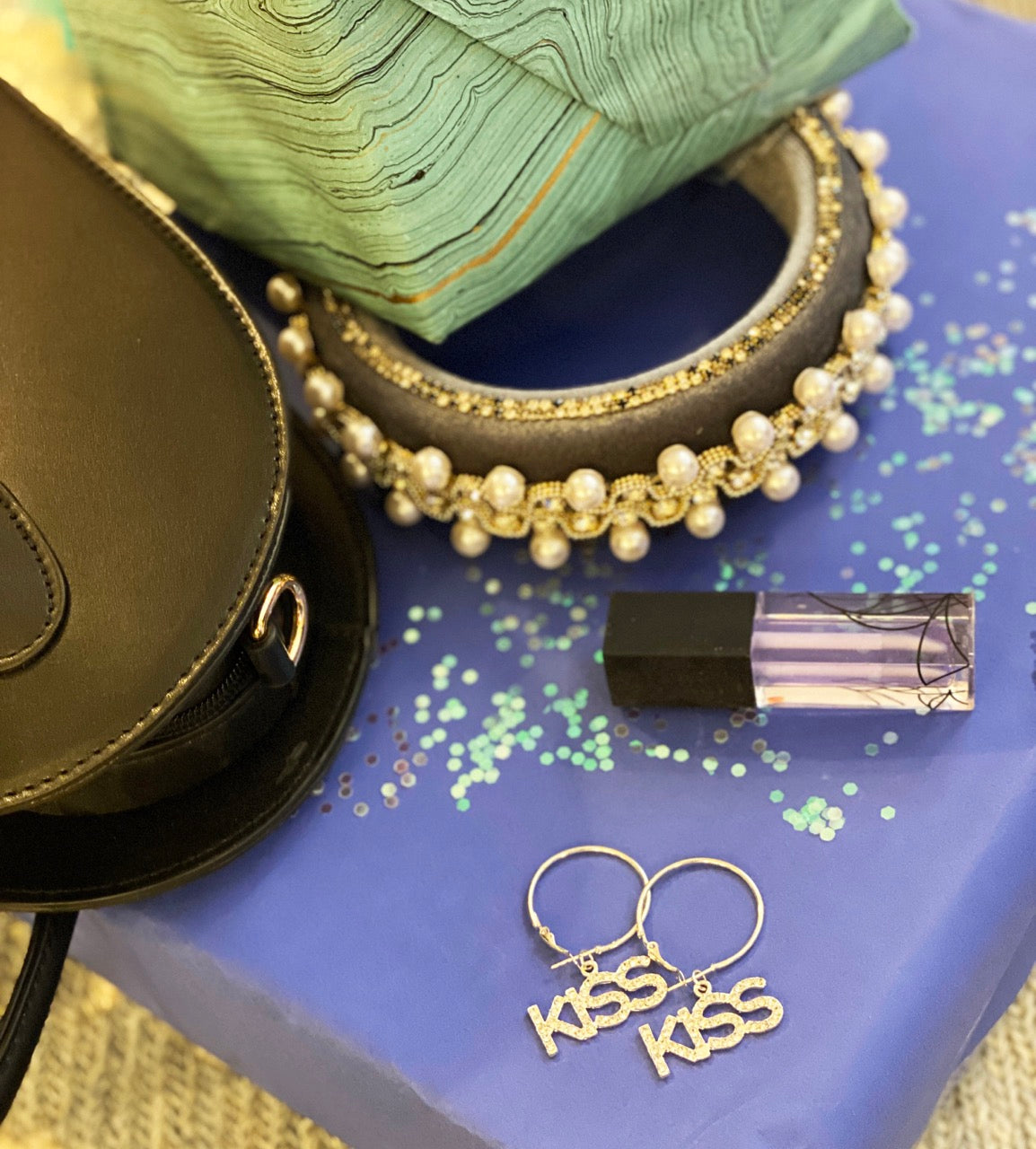 Crystal embellished kiss earrings hanging from metal hoops in silver and gold