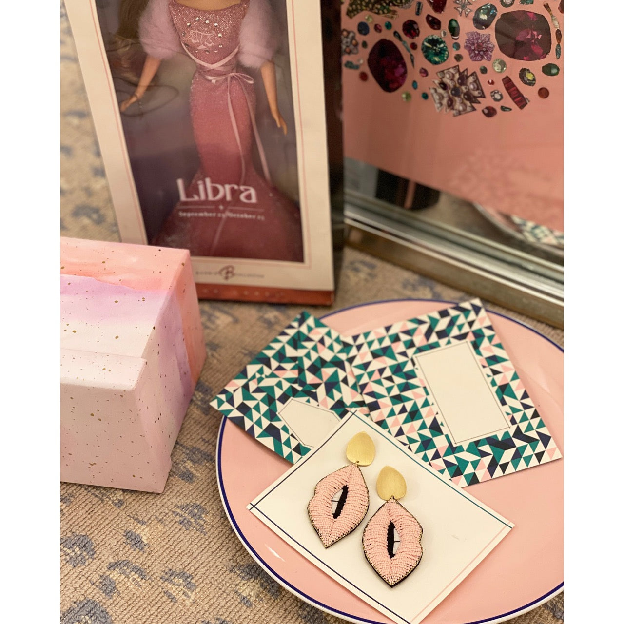 Playful yet edgy earrings featuring pink lip bead designs, gold metal tops, and embroidered retro boombox and portrait motifs on felt backings.