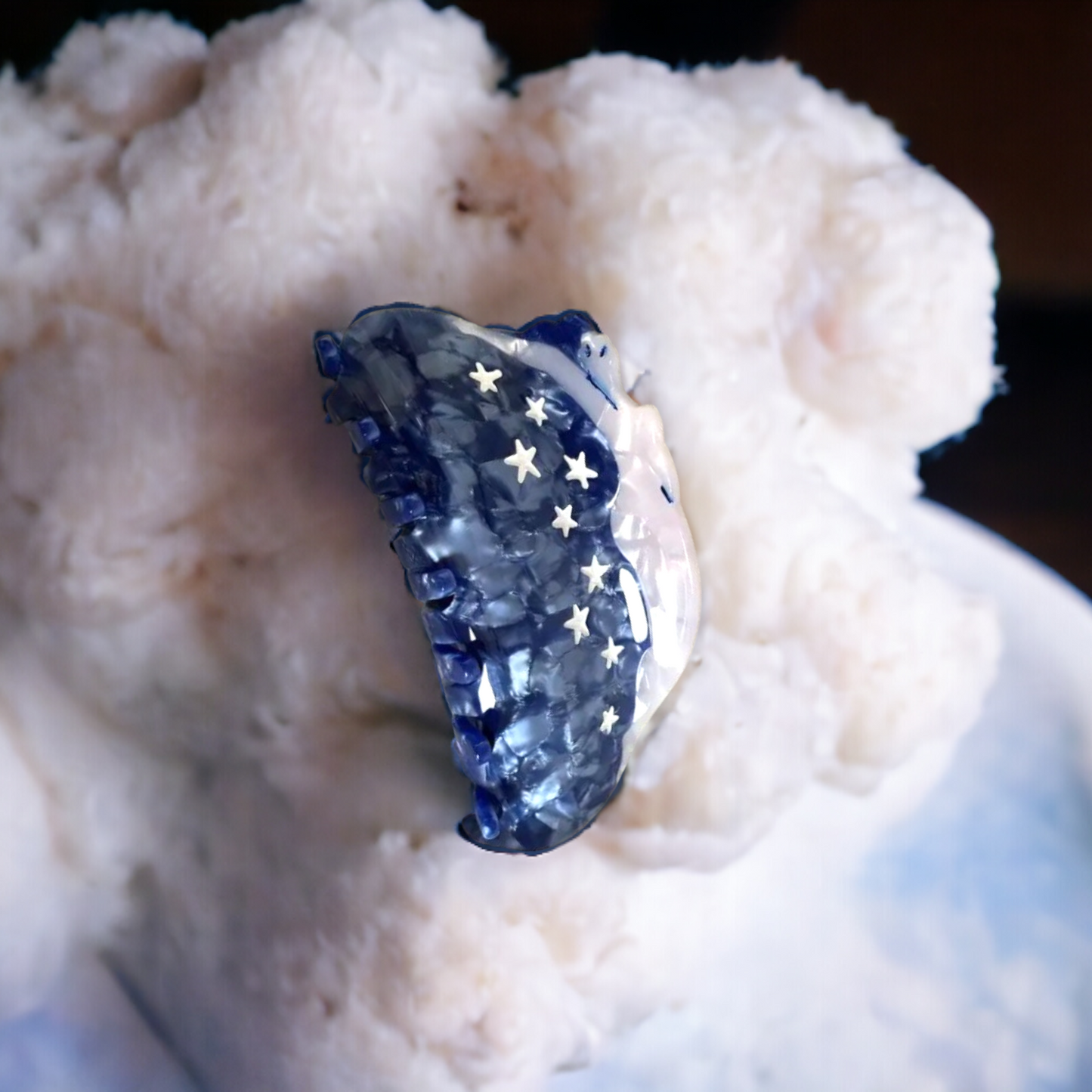 Celestial-inspired hair clip with a woman lounging across a blue night sky with stars.
