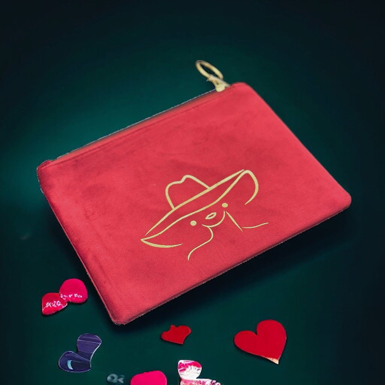 Pink suede pouch with the outline of a mysterious lady on it in gold.