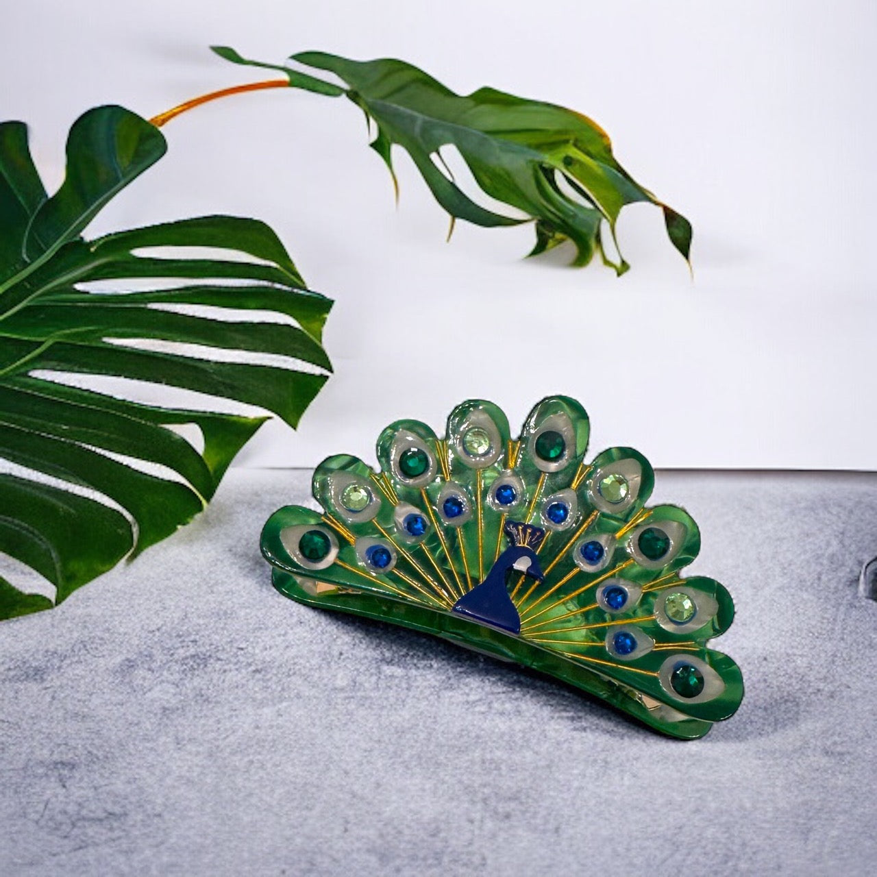 Perfect for special occasions and everyday wear, this eye-catching peacock hair clip features a dazzling array of blue and green stones set in an intricate metal design, making it a must-have for any accessory collection.