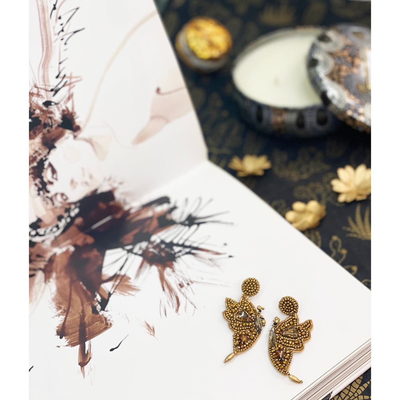 Handmade beaded butterfly earrings with “GET EVEN” text patches and sparkly gemstone accents