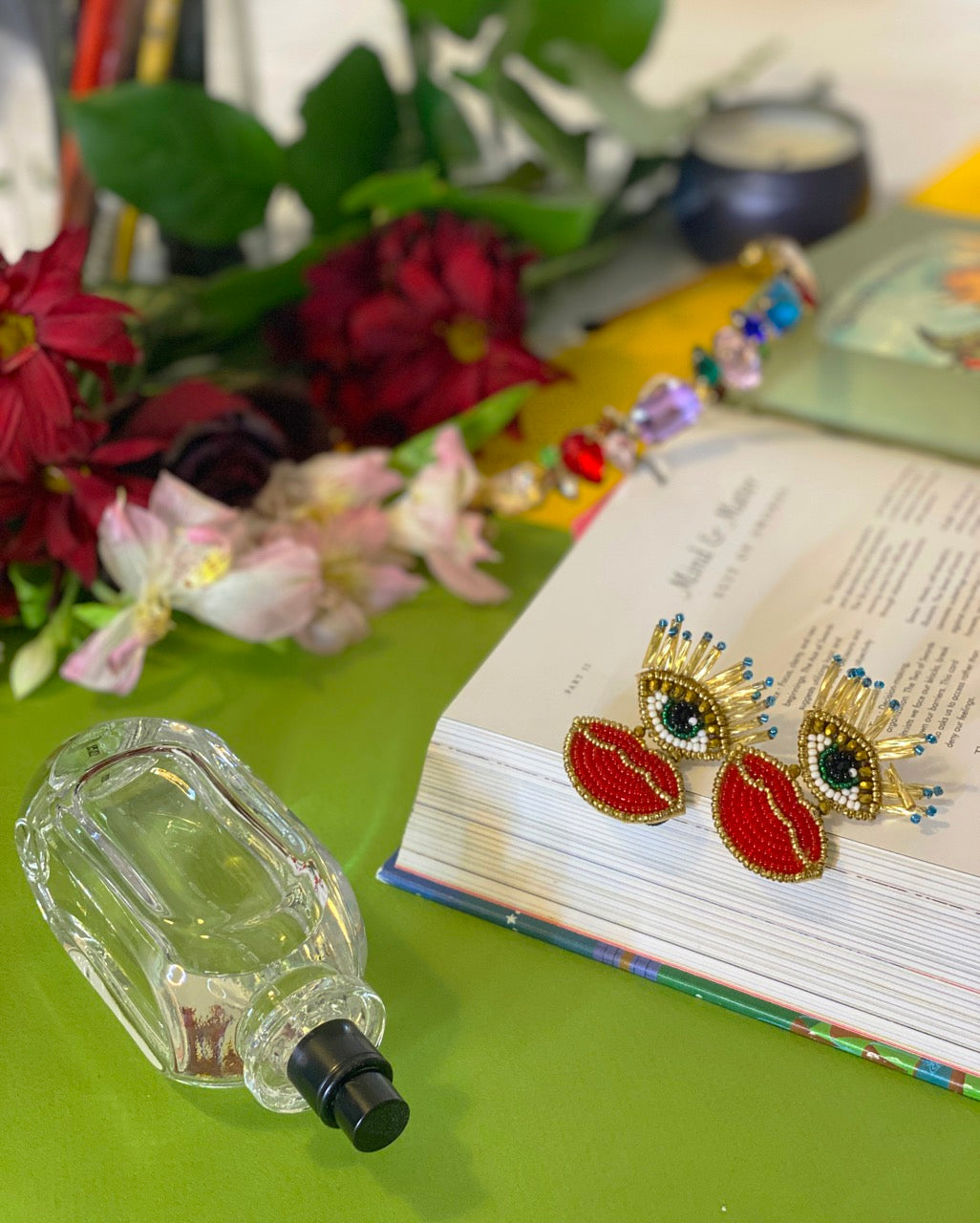 Handcrafted beaded earrings featuring red lips, gold lashes, and edgy message on back