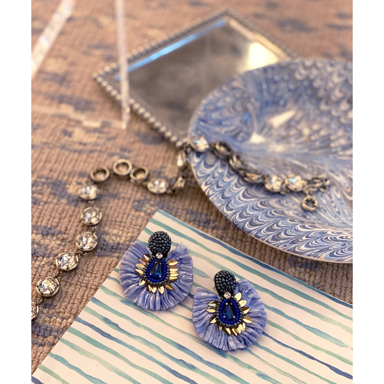 Dreamy blue earrings with layered texture, beaded center, and embroidered surprise message