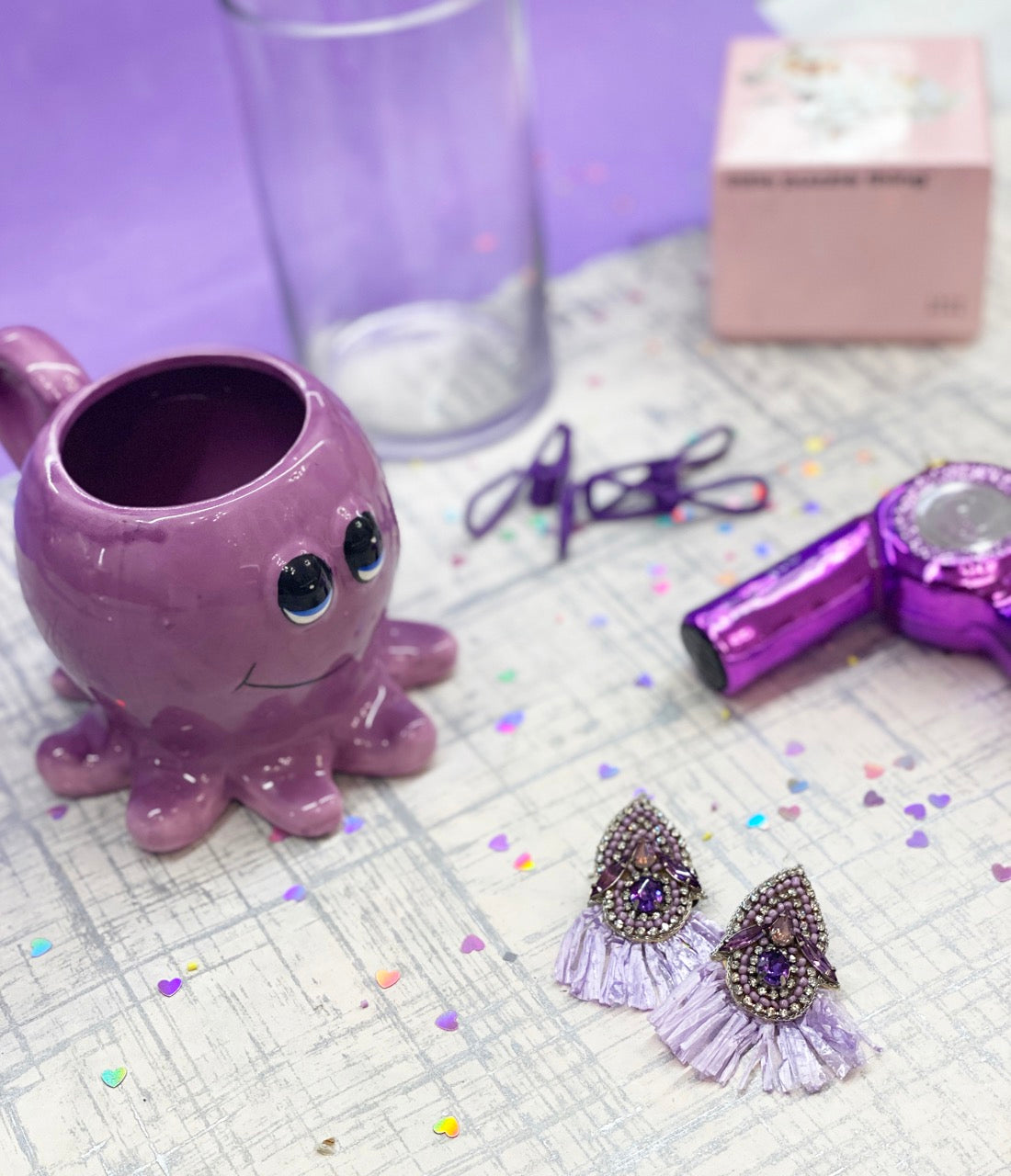 Unique Purple Reign earrings with artistic beading, purple fringe, and fun "A-OK" patch, perfect for stylish outfits.