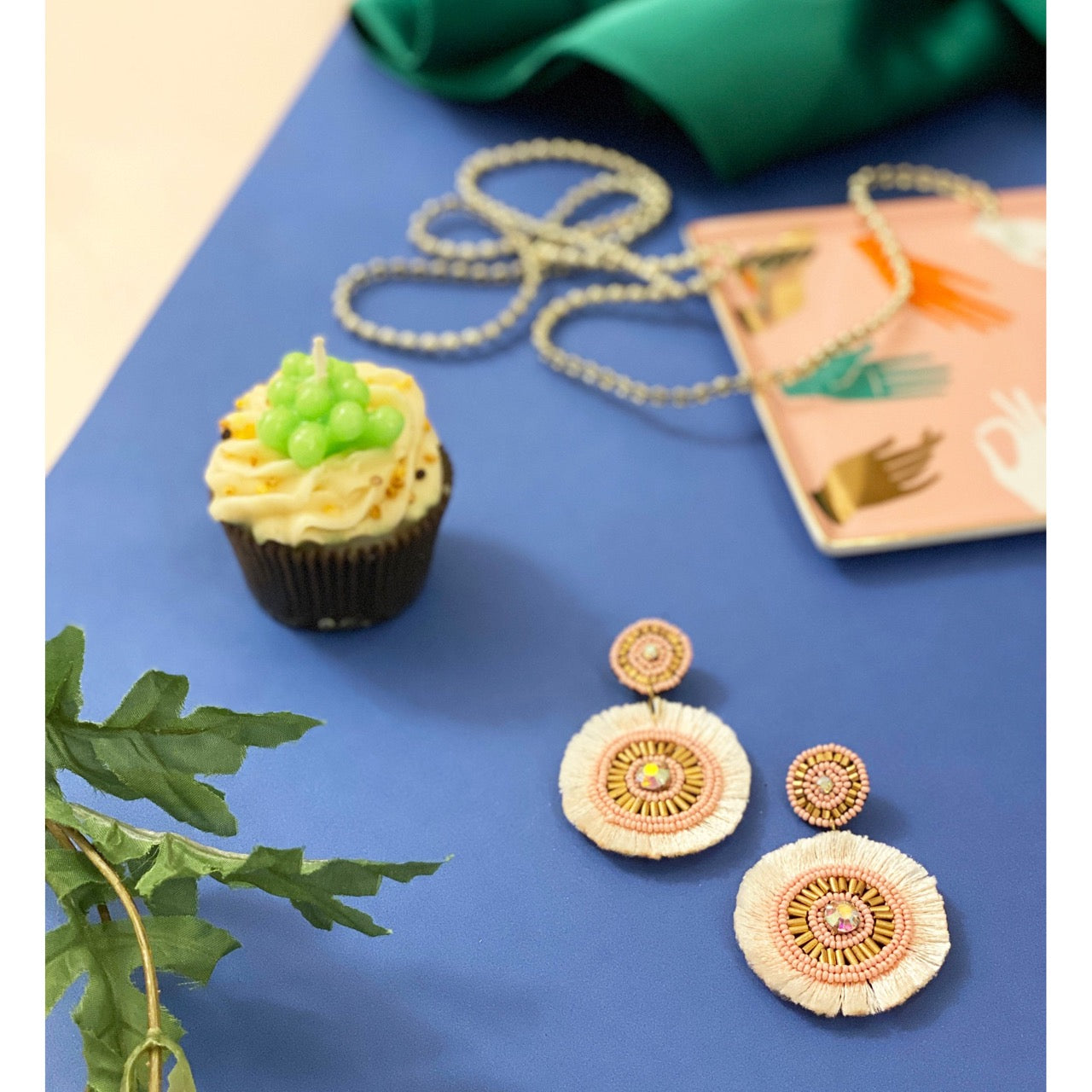 Unique blush pink earrings with artistic beading, soft palette, and fun "Texas Love" patch, perfect for stylish outfits.