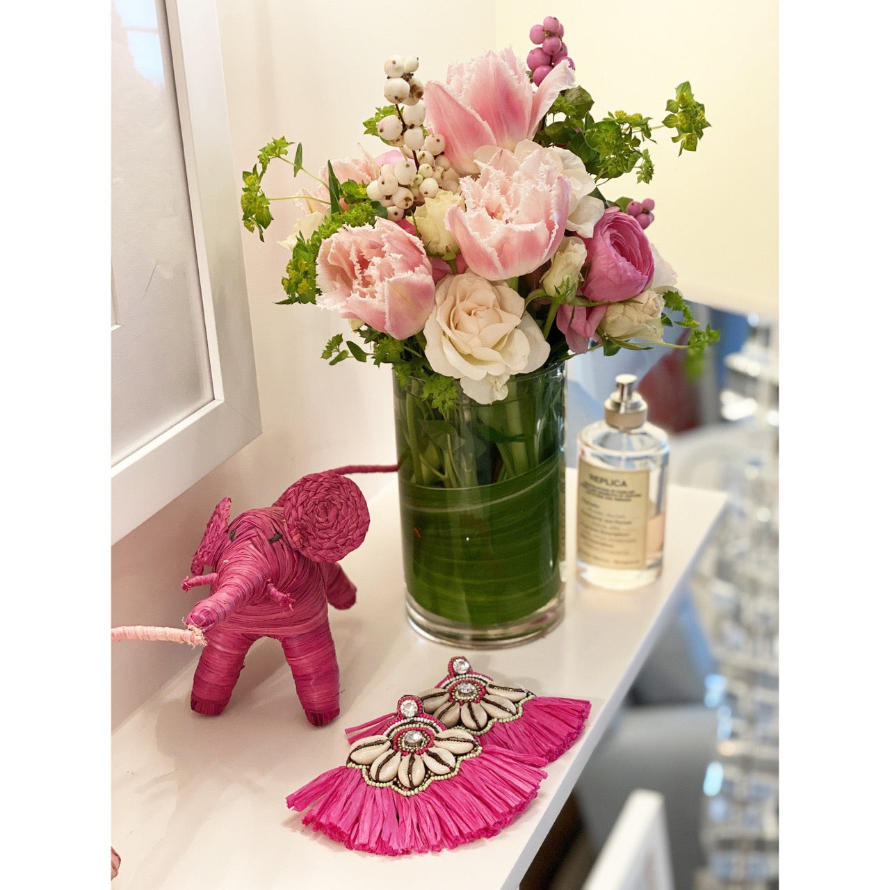 Playful fuchsia earrings with fringe, cowrie shells, and rhinestone details, ideal for summer vacations and beachwear.