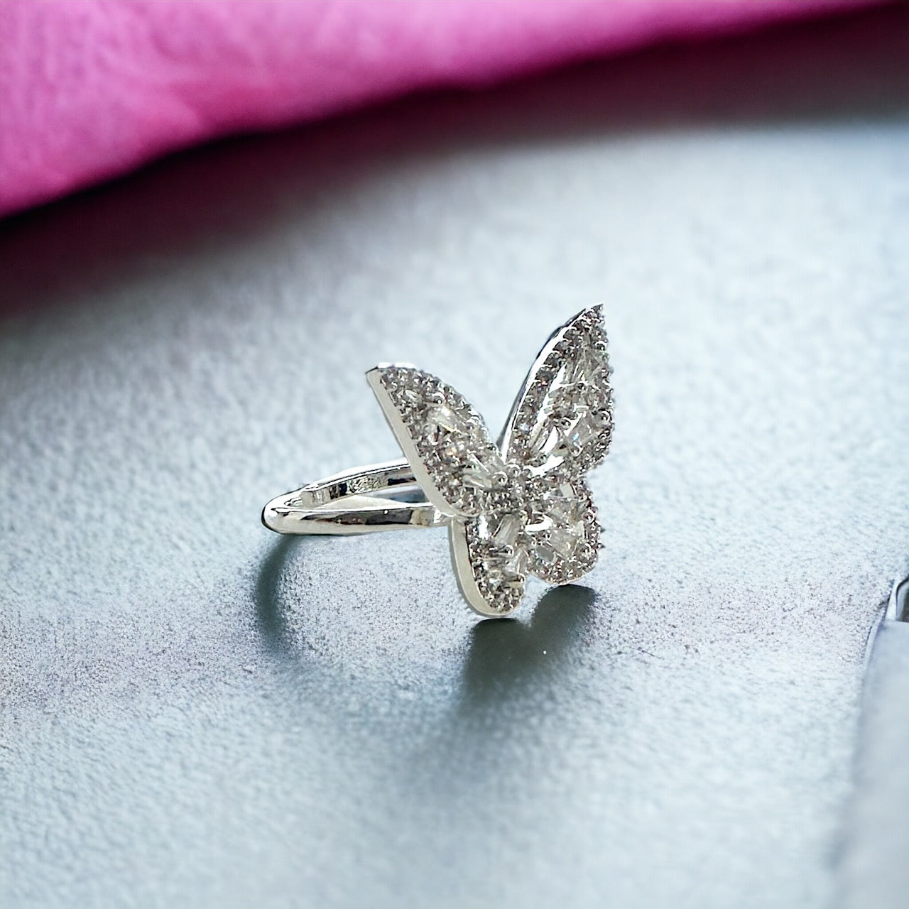 Delicate butterfly ring made of fine silver features intricate detailing and a touch of sparkle.