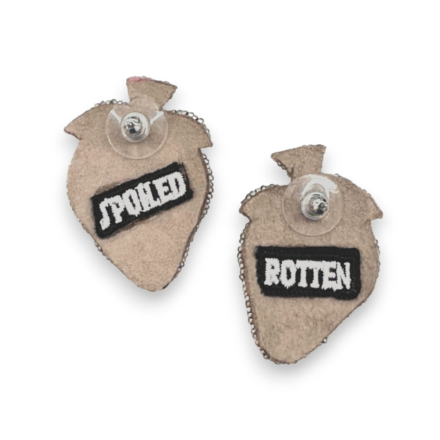 The back of strawberry shaped earrings have the patches "Spoiled" and "Rotten" on them.