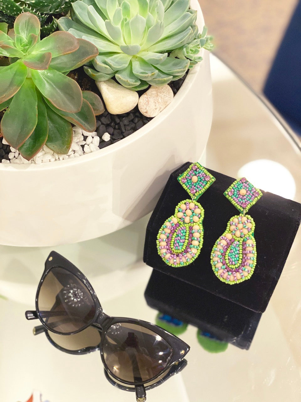 Oversized statement earrings in green with detailed beadwork and humorous text accent