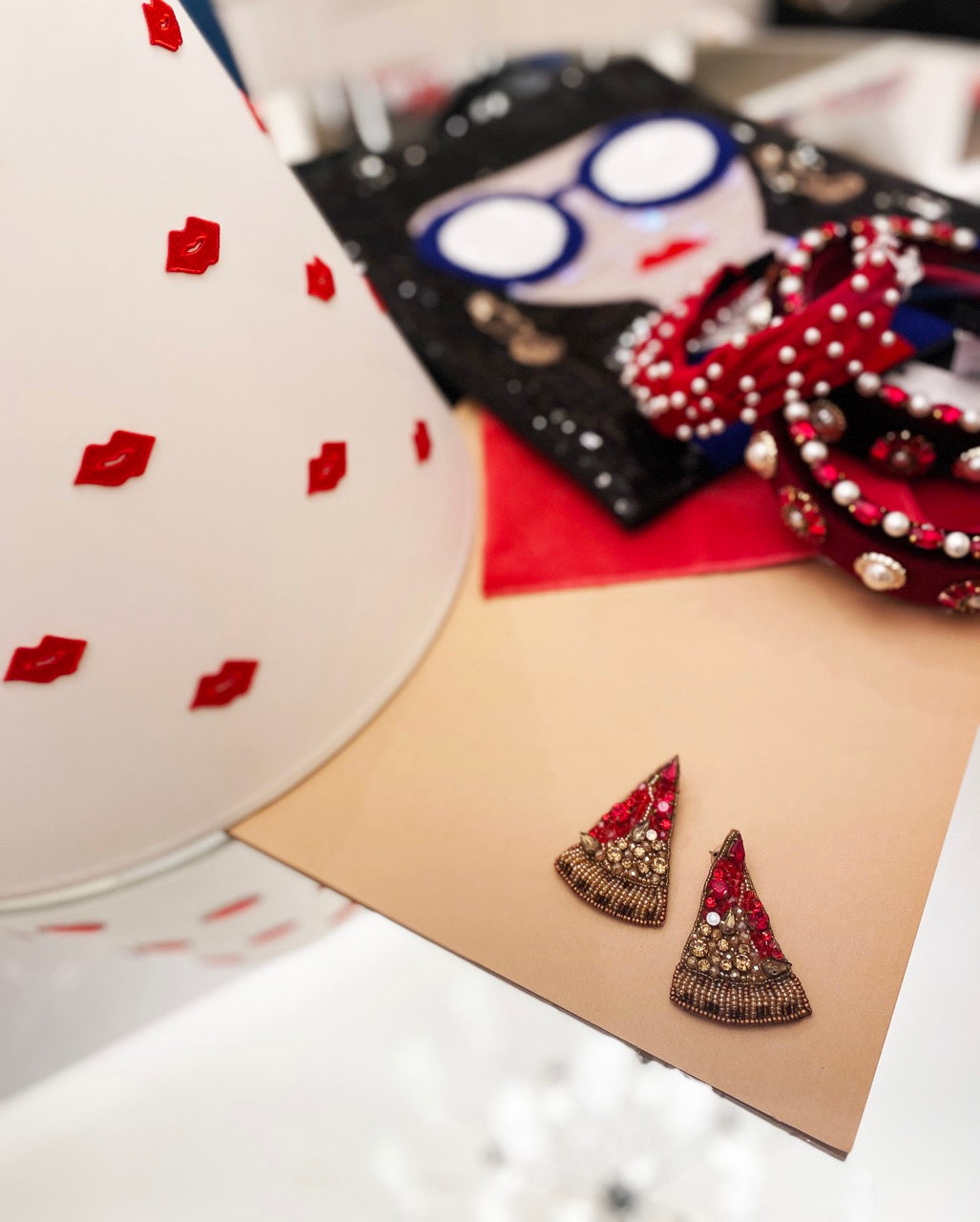 Creative fashion earrings featuring a bedazzled pizza slice design with intricate beadwork and an "OMG" patch.