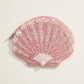 Blush and gold sequin seashell pouch with pearl accent on white background