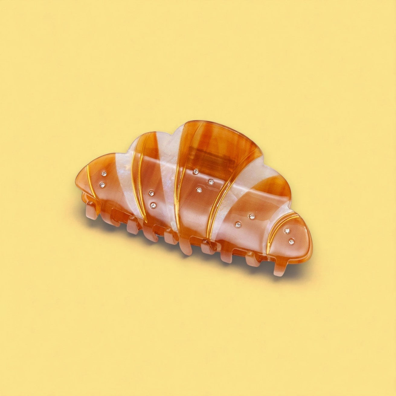 Orange croissant design hair clip on yellow background