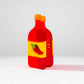 Full front view of a novelty hot sauce claw clip in red, yellow, and orange acrylic with pepper graphic.