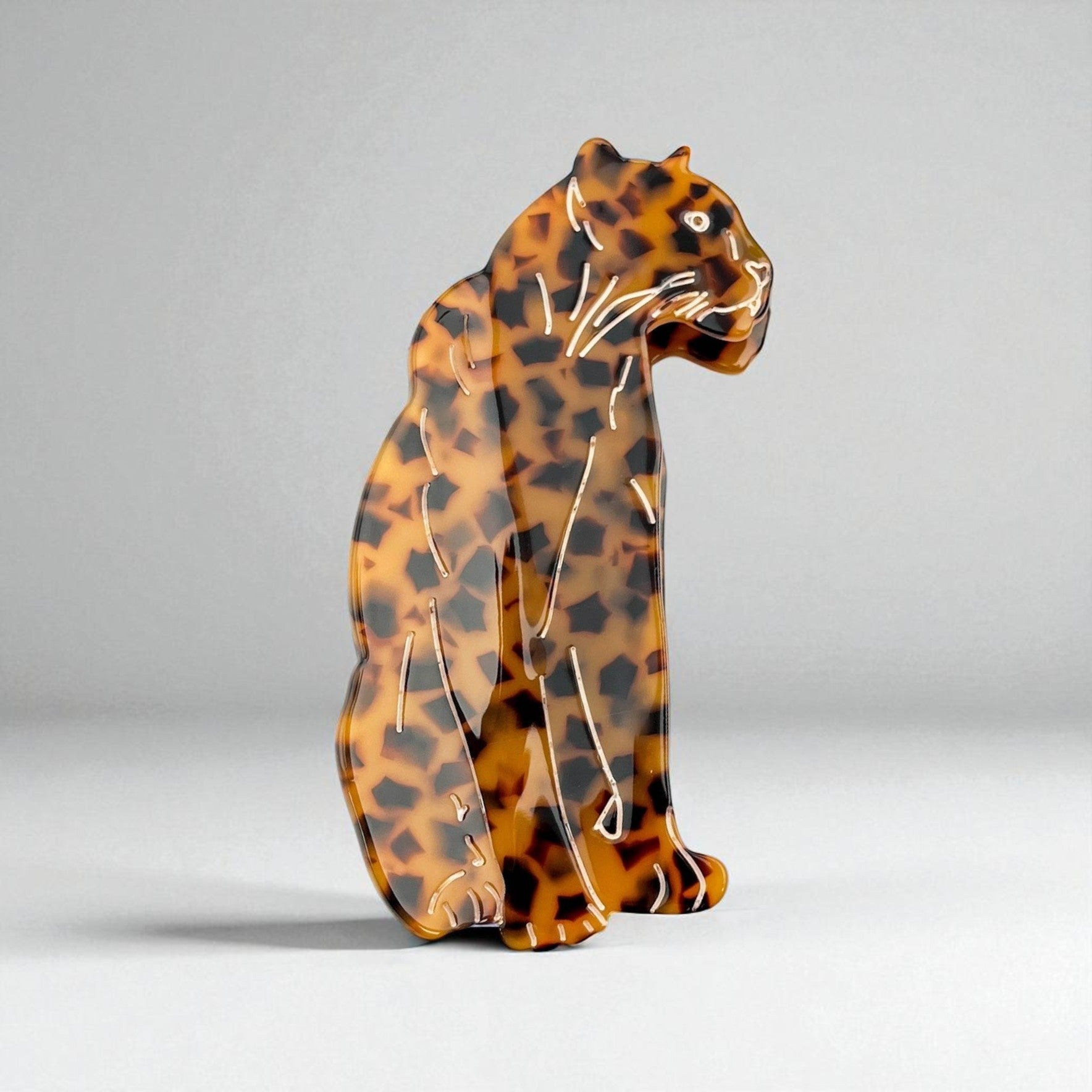 Tortoise shell hair clip shaped like a leopard, featuring defined whisker and tail details on a plain background.
