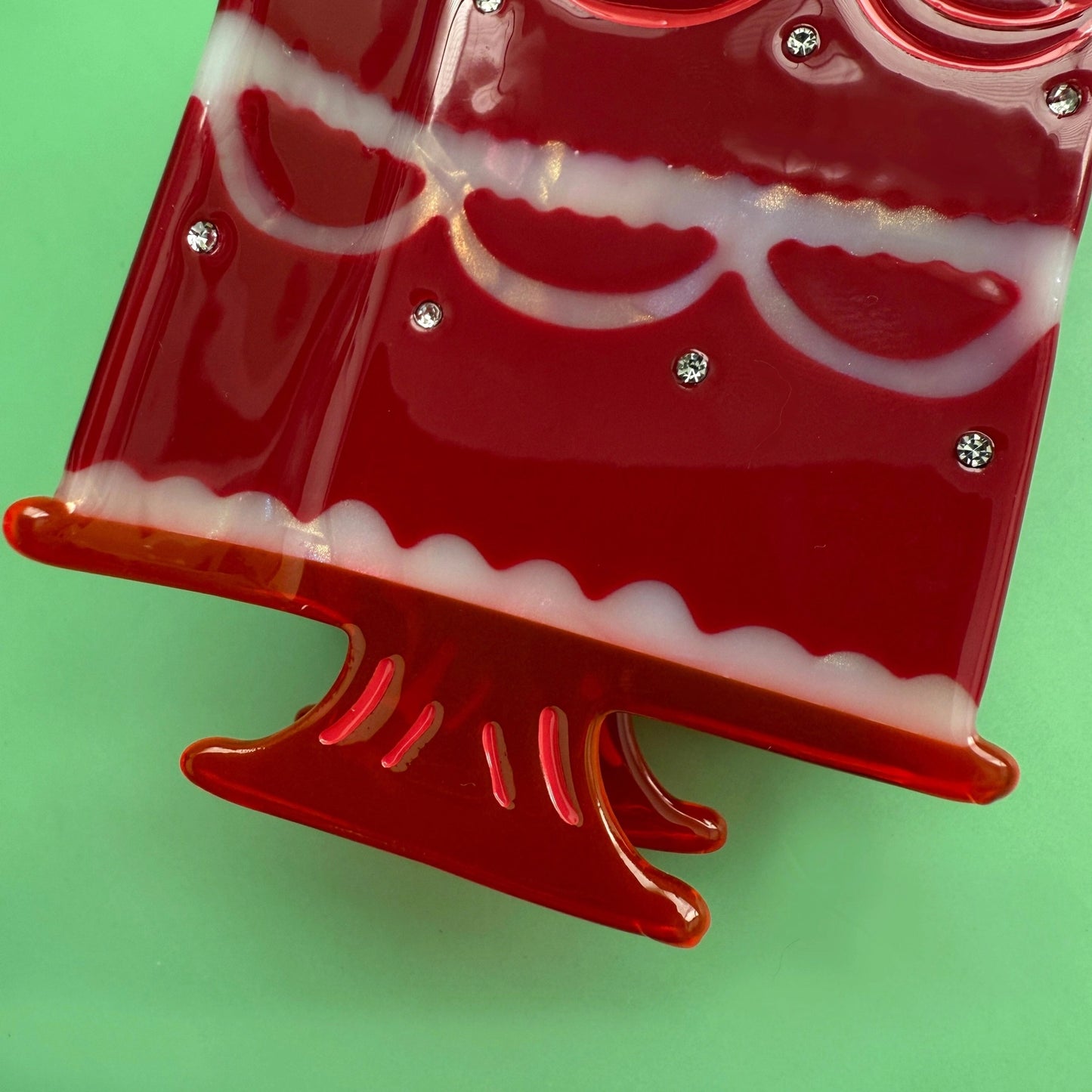 Close-up of cake stand base on the red strawberry cake hair clip