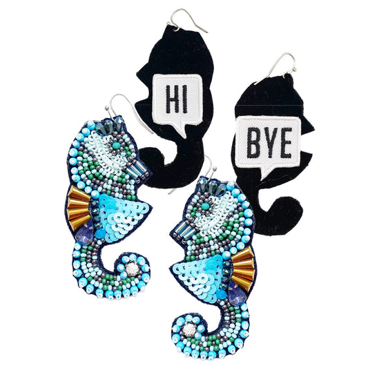 Sapphire seahorse earrings with intricate beading and a playful "Hi/Bye" patch design on the back.